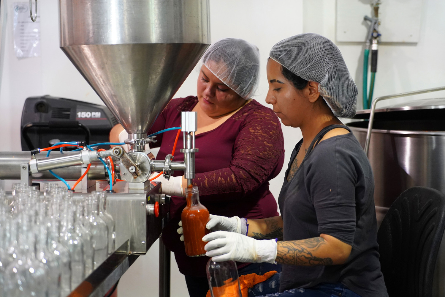 Worker Liz Franco, right, fills a bottle of Miss Marie’s Spaghetti Sauce while Griselda Gonzalez twists the cap onto another bottle at Bluegrass Superior Foods in Louisville, Ky., Oct. 22. The sauce was created by Father Jim Sichko of the Diocese of Lexington and part of the proceeds of sauce sales are donated to the diocese and Southeast Texas Hospice.